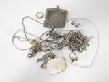 a pile of silver jewelry on a white surface