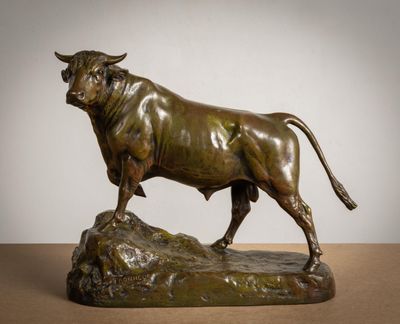 bronze statue of a bull standing on a rock on a table