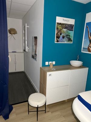 une photo d'une salle de bains avec un mur bleu et un lavabo blanc