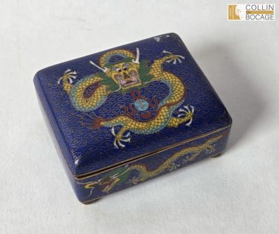 une boîte bleue ornée d'un dragon, posée sur une table