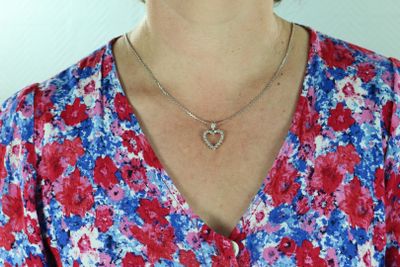 une femme qui porte un collier orné d'un cœur