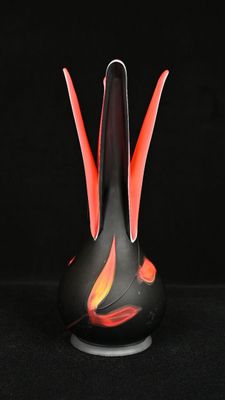 un vase noir dans lequel on voit une flamme rouge