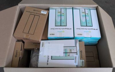 de nombreuses boîtes contenant des appareils électroniques, empilées dans une boîte posée par terre