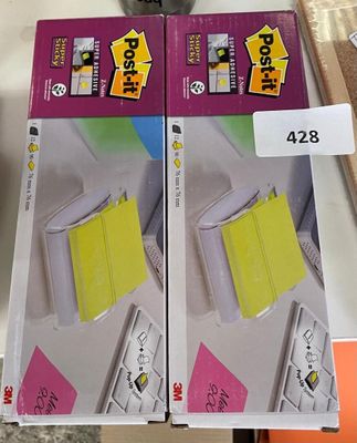 two boxes of post - it notes on the table