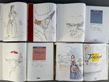 many books that are open on a table