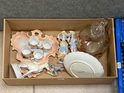 une boîte posée par terre, contenant de nombreux objets