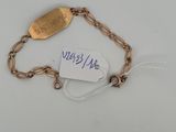 a close up of a gold bracelet with a tag on it