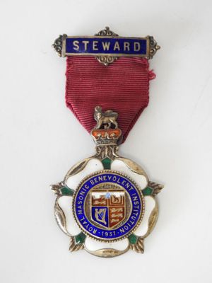 medal with a red ribbon and a blue and white badge on it
