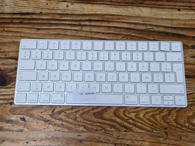 a white keyboard sitting on a wooden table next to a mouse