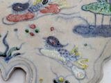 a decorative plate with fish and plants painted on it