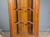 un meuble en bois avec une porte en verre dans une pièce