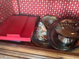 deux plats en argent posés sur une table en bois, avec une boîte rouge