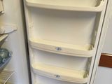 a white refrigerator with its door open in a kitchen