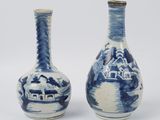 une paire de vases bleus et blancs ornés de maisons sur fond blanc