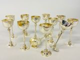 plusieurs gobelets et cuillères en argent posés sur une surface blanche