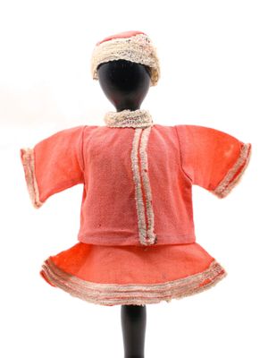 un mannequin vêtu d'une robe rouge et d'un chapeau