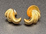 a pair of gold toned earrings with swirl design
