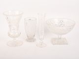 trois vases en verre et un bol posés sur une table