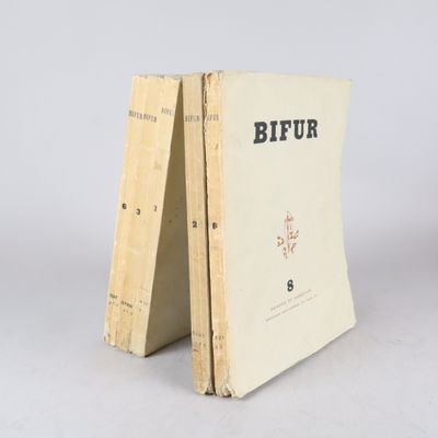 un vieux livre posé sur une table en bois à côté d'un mur blanc