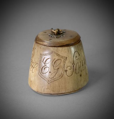 une petite boîte en bois portant une inscription, posée sur une table