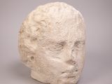 sculpture blanche représentant une tête sur une surface grise