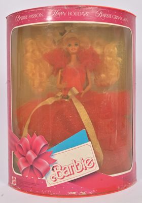 une poupée dans une boîte rose, ornée d'un ruban rose et d'un nœud rose