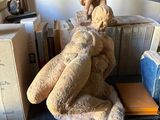 a statue of a man sitting on top of a pile of books