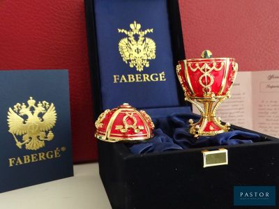 une coupe Fabergé rouge et or ainsi que d'autres objets dans un coffret noir