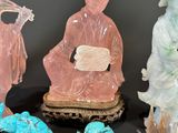 several jade figurines are displayed on a table with other figurines