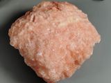 a piece of pink rock on a plate next to a fork