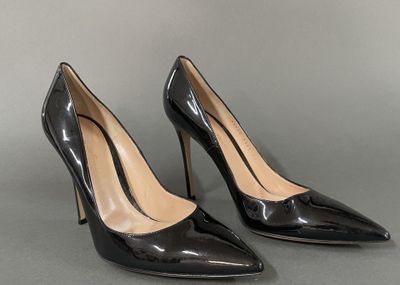 a pair of black high heeled shoes on a grey surface