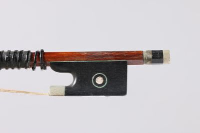 an old violin bow with a string attached to it on a white surface