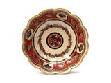a red and gold plate with a floral design on it