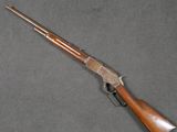 a rifle with a wooden handle on a gray surface