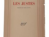 un vieux livre portant des inscriptions rouges, posé sur une surface blanche