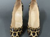 a pair of leopard print shoes on a grey surface