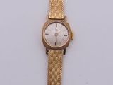 une image d'une montre-bracelet en or sur une surface blanche