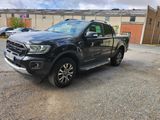 the black ford ranger is parked in a parking lot