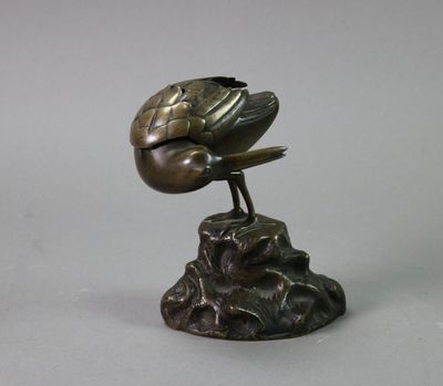 statue of a bird perched on a rock with a bird on it ' s head
