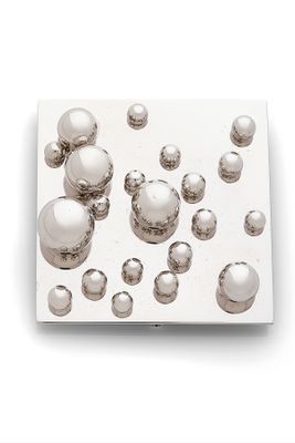 a lot of silver balls floating on a white surface