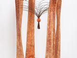 a sculpture made of wood and metal on a white pedestal