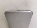 a close up of the back of a silver phone on a table