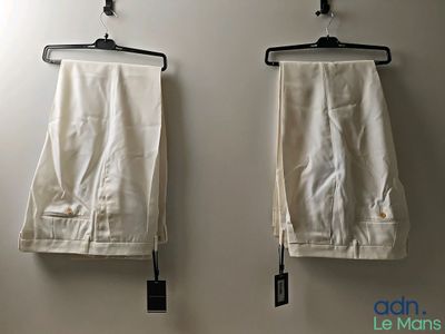 two pairs of pants hanging on the wall next to each other