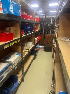 a long shelf with many boxes on it in a room