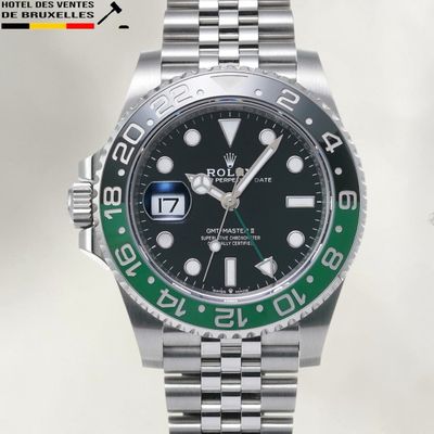 une montre Rolex avec une lunette verte sur le bracelet