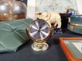 a small clock sitting on a table next to other items