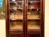 a large wooden cabinet with glass doors in a room