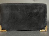 a black leather wallet with gold accents on a table