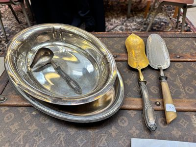 un plateau en argent avec une cuillère et un couteau posés sur une table