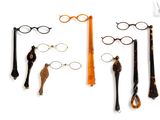 several pairs of glasses and a pair of scissors on a white surface